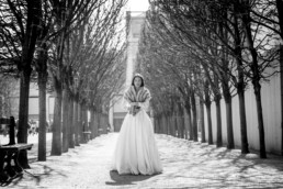 La mariée attendant au milieu d'une allée d'un parc parisien