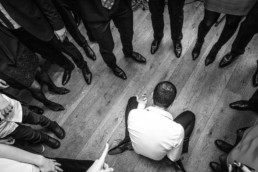 Homme jouant du air guitare au sol au milieu des invités lors de la soirée