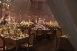 Salle de mariage décorée avec des tables élégantes et des chandeliers.