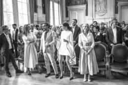 Les mariés debout avec leurs proches dans la salle.