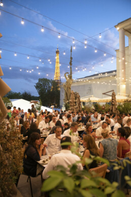 Les invités dînent en terrasse avec la tour Eiffel.