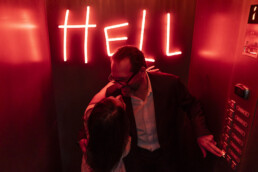 Un couple s’embrasse dans un ascenseur d’hôtel.