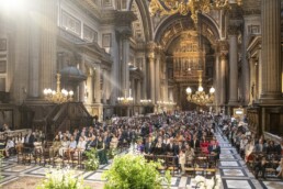 Invités assis dans une grande église ornée pendant une cérémonie de mariage.