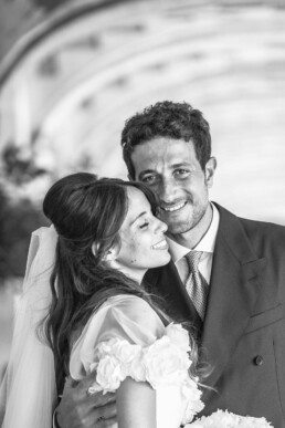 Un couple de mariés s’enlace et sourit lors d’un portrait de mariage.