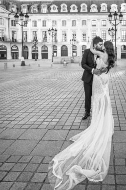 Mariés s’embrassant sur la place Vendôme à Paris.