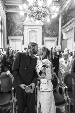 Les mariés s’embrassent pendant la cérémonie devant leurs invités.